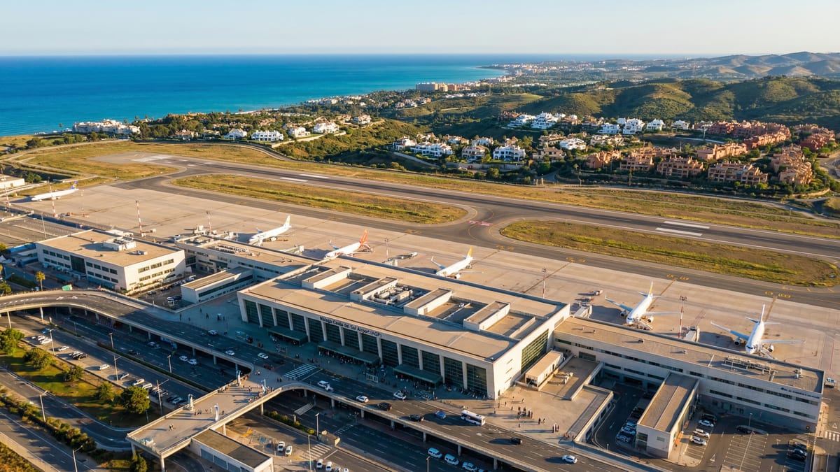 Luftaufnahme des modernen Flughafens Málaga an der Costa del Sol mit Küstenlandschaft und luxuriösen Villen im Hintergrund.