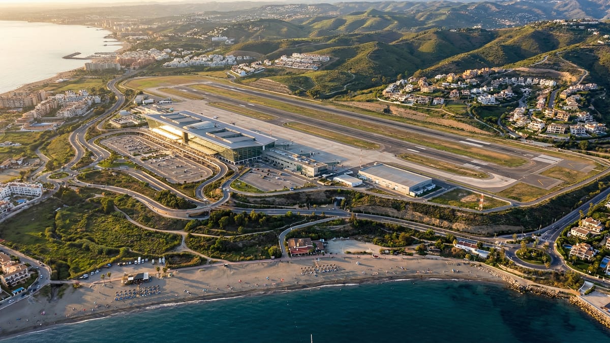 Luftfoto av Málaga Lufthavn med Costa del Sols landskap, viser moderne terminal, rullebaner og luksuriøse villaer ved Middelhavet.