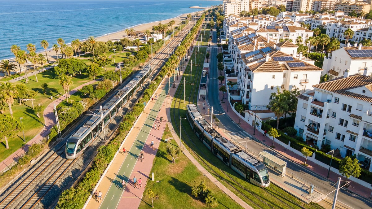 Vue aérienne de la Costa del Sol montrant l'infrastructure moderne des transports publics, y compris des trains électriques et des tramways, dans un cadre méditerranéen.