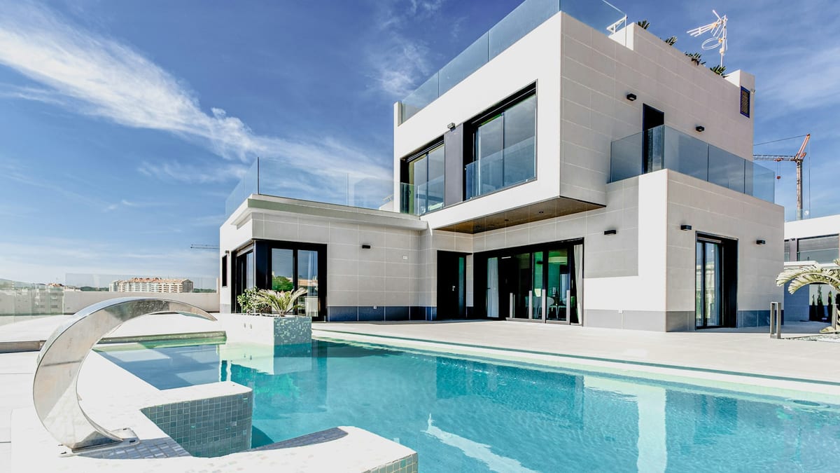 Luksuriøs eiendom med typisk middelhavsstil i Costa del Sol, omringet av palmer og blå himmel.